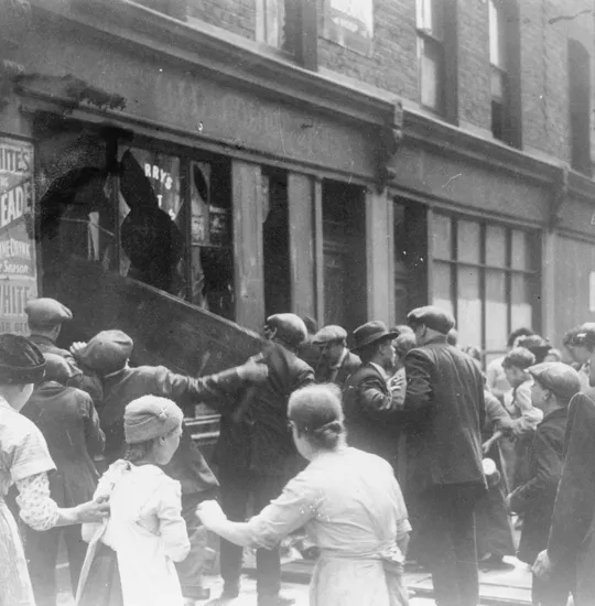 Crowd of rioters breaking the windows of a German-owned shop in East London, following the sinking of the liner Lusitania on 7 May 1915.